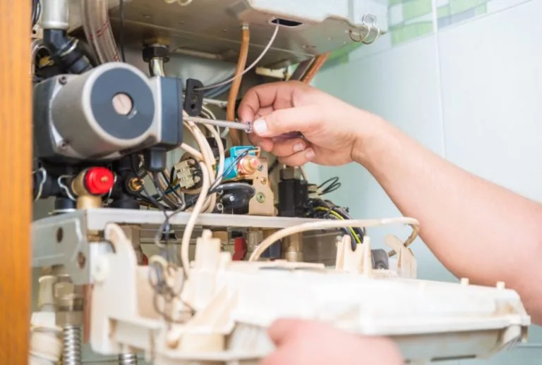 An HVAC technician performing furnace repair and maintenance, addressing issues such as banging, popping, screeching, sq