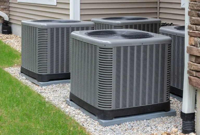 An air conditioner unit outside a residential home, commonly used in central air systems, heat pumps, or standalone cool
