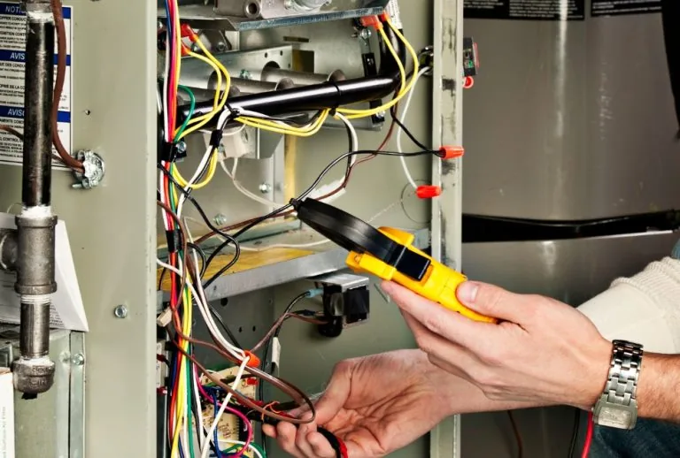 HVAC technician performing emergency furnace repair, diagnosing furnace issues for efficient heating. Paradise Heating a