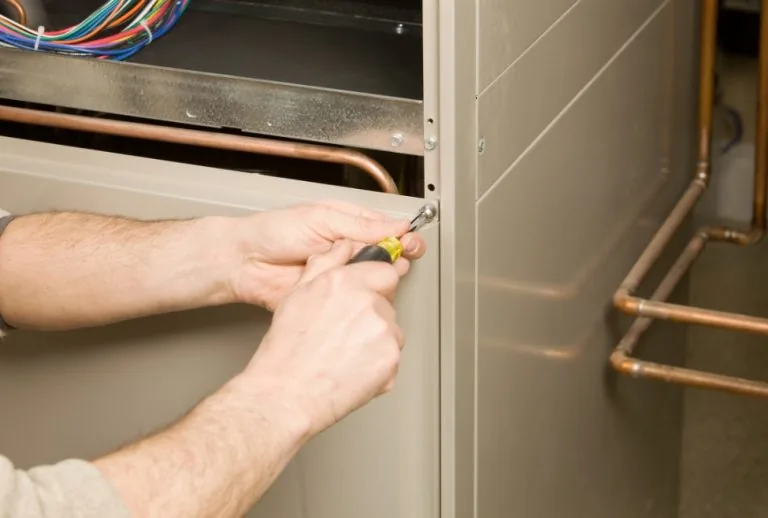 HVAC technician installing a high-efficiency furnace – learn how to get a tax credit for a new furnace with Paradise Hea
