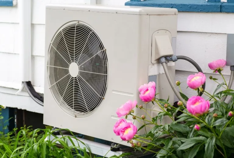 Energy-efficient heat pump installed outside a building, offering superior heating and cooling compared to gas or electr
