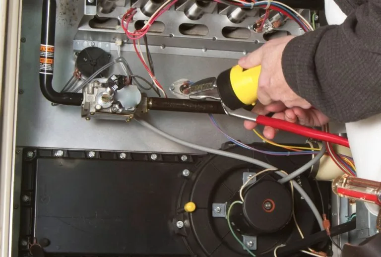 HVAC technician servicing a furnace limit switch to ensure optimal heating system performance in a residential home, pro