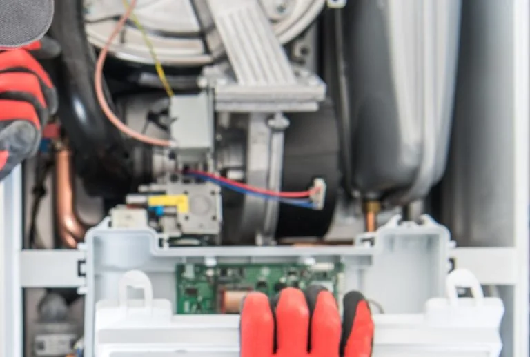 HVAC technician repairing a heating furnace, diagnosing furnace error codes. Paradise Heating and Air provides expert fu