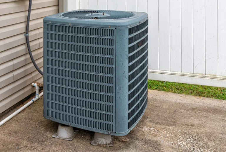 Residential outdoor air conditioner unit showing potential signs of compressor failure—Paradise Heating and Air explains
