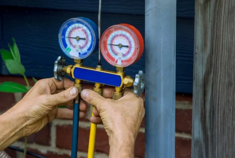 HVAC technician checking refrigerant levels in air conditioner with gauges, diagnosing low refrigerant issues and prepar
