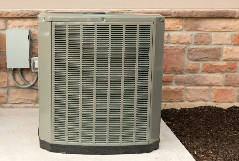 Outdoor residential air conditioner unit representing AC system components, used by Paradise Heating and Air for service