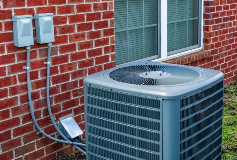 Outdoor air conditioning unit illustrating what is the most expensive repair on an AC unit, including AC compressor repl