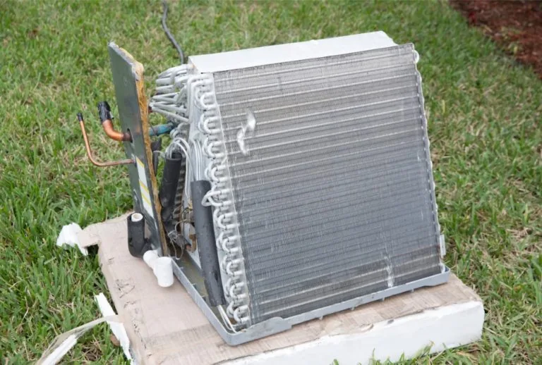 Close-up of an air conditioner evaporator coil showing dirt buildup, potential freezing, and airflow restriction issues 